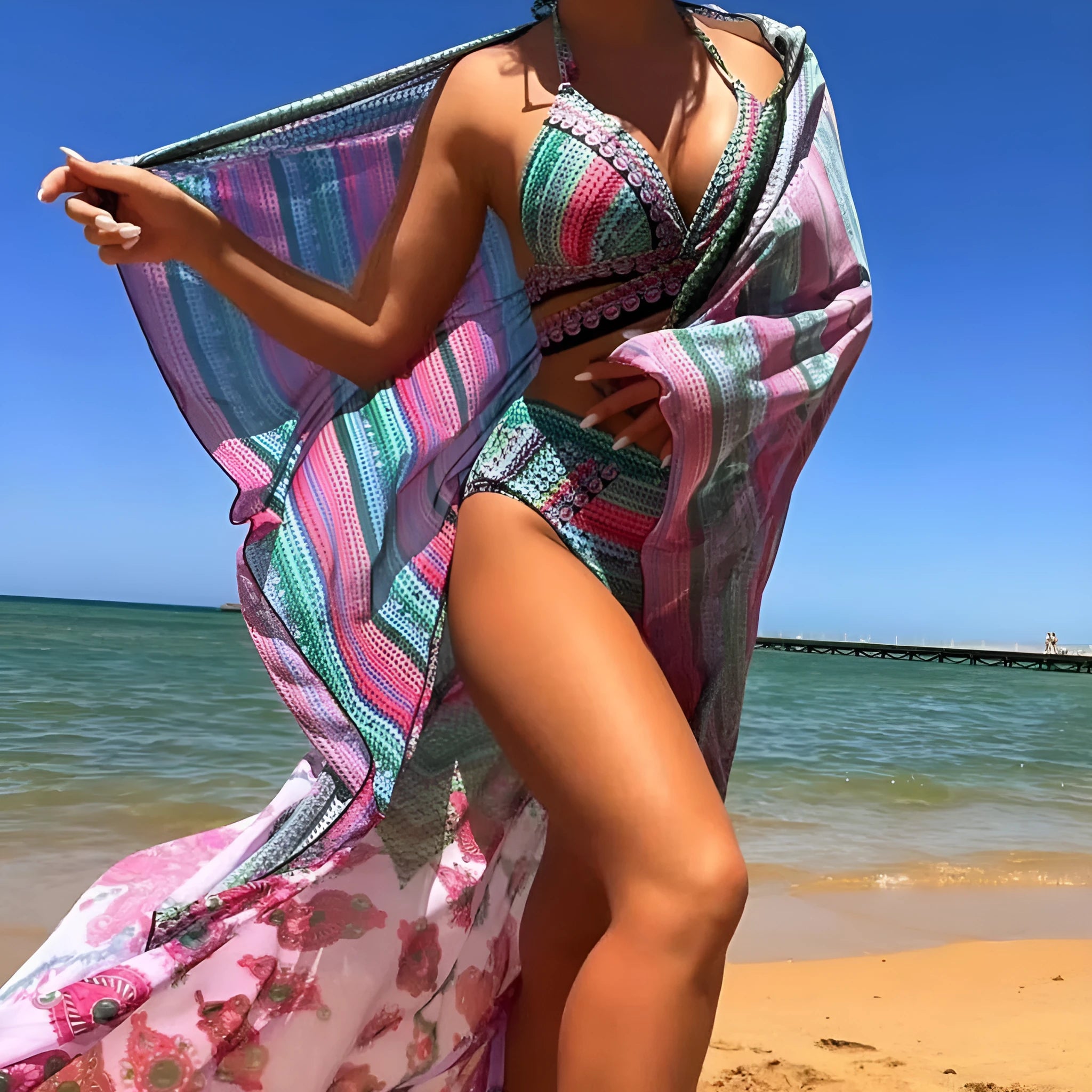 Women's blue three-piece bikini set with cross bandage bra, high-waist bottoms, and sheer veils laid flat.