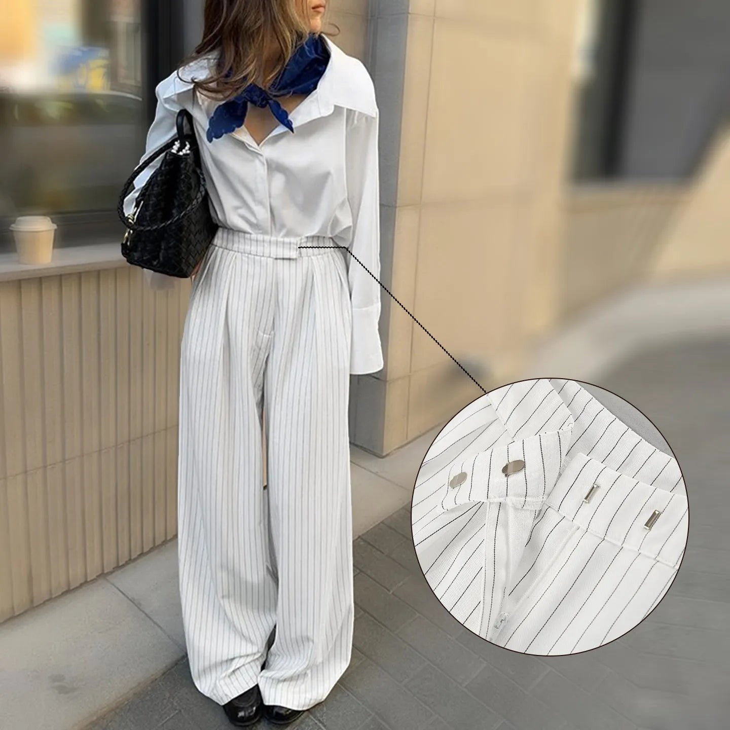 White striped wide-leg women's trousers with side zip, laid flat to show loose fit and pattern.