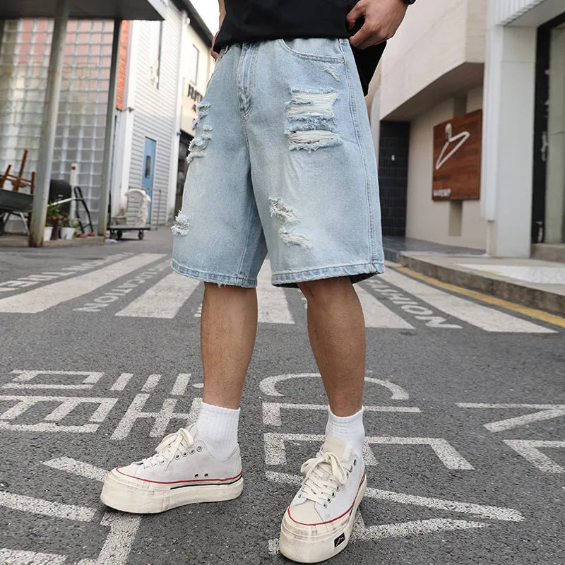 Light blue loose fit ripped denim shorts with distressed details on a straight leg.