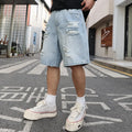 Light blue loose fit ripped denim shorts with distressed details on a straight leg.