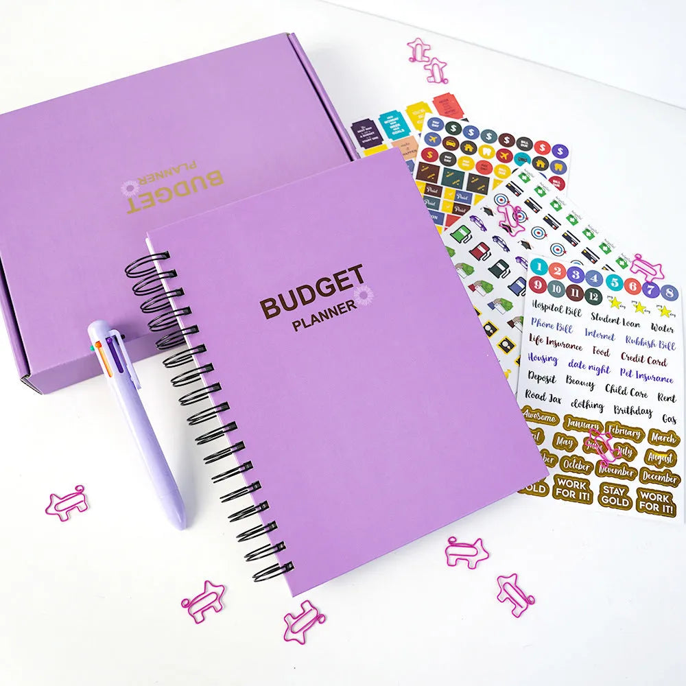 Purple coil-bound financial planning notebook with budgeting stickers and pen on Daolin paper