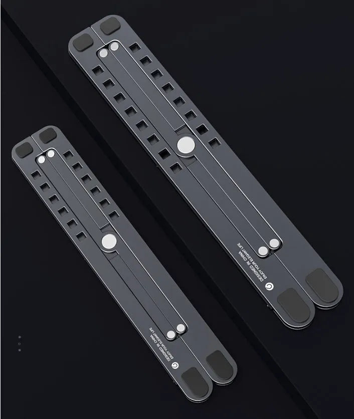Aluminum foldable laptop stand in silver colour, shown adjusted to an elevated height with a laptop on top.