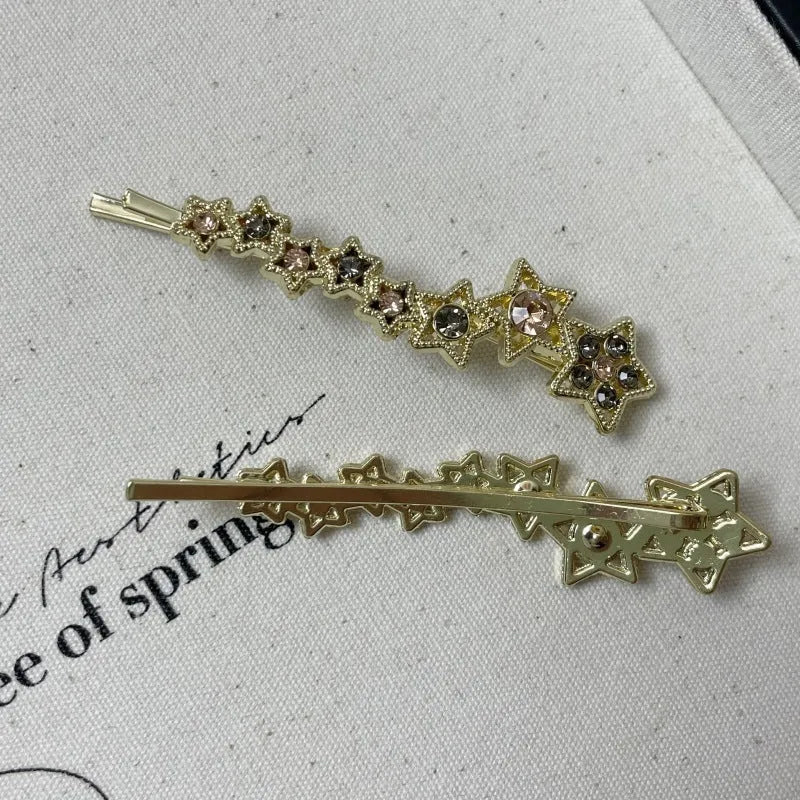 Golden hair clip barrette with a rhinestone five-pointed star, shown on a side angle.