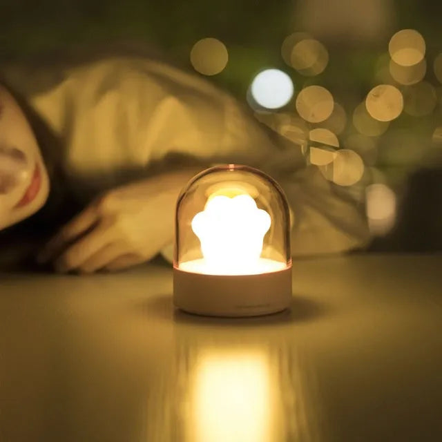 Grey and pink cat paw shaped USB rechargeable night light with music box on a desk