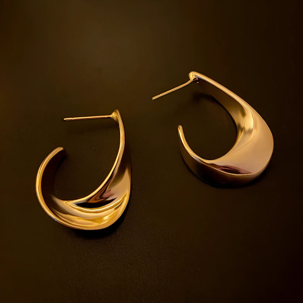 Metal twisted geometric hoop earrings with electroplated gold or silver finish showing round wire design