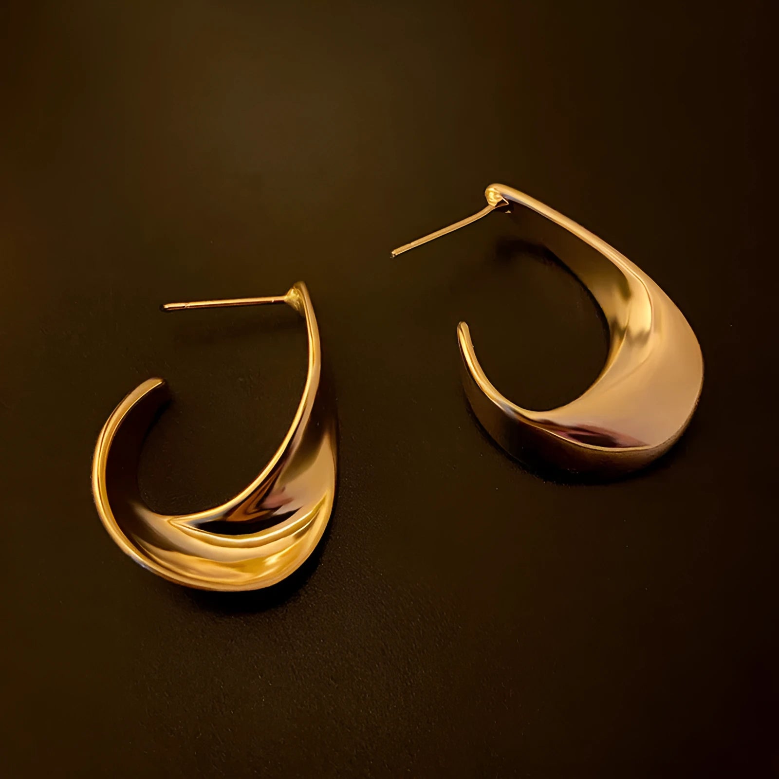 Metal twisted geometric hoop earrings with electroplated gold or silver finish showing round wire design