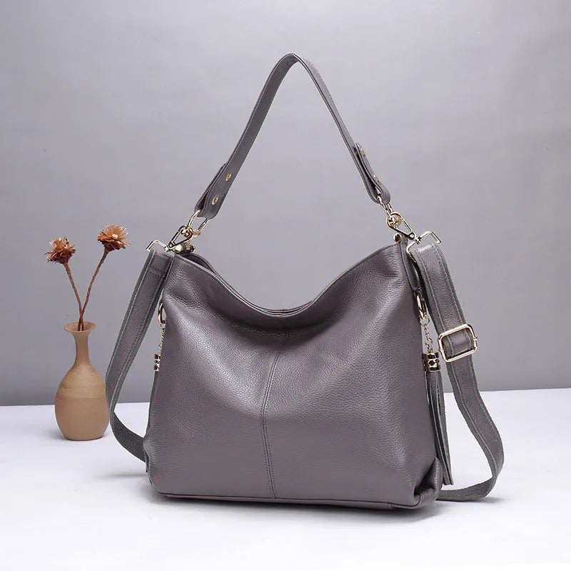 Genuine leather vertical square crossbody bag in black, showing front sandwich pocket and sewing line details.