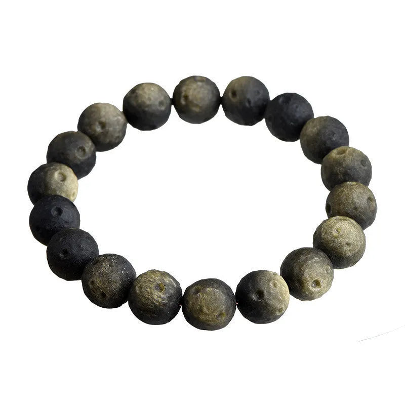 Natural obsidian crater ball bracelet showing polished spherical beads in silver stone meteorite colour with visible mineral texture