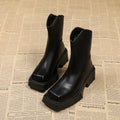 Women's black square-toe platform Martin boots with a block heel and rear zip on a white background