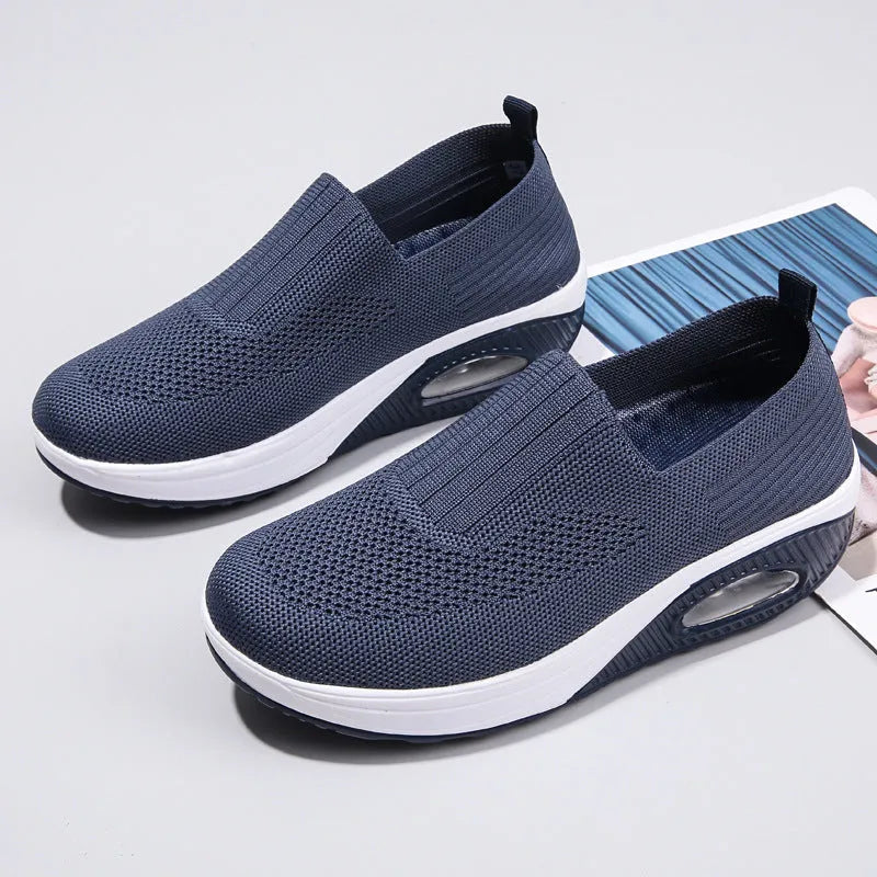 Women's black mesh running shoes with air cushion midsole and round toe on a grey background.