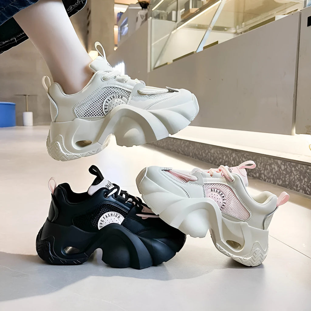 Women's pink platform sneakers with a thick sole and cross ankle straps on a white background.