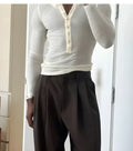 Men's cream coloured ribbed long-sleeve henley top with button placket.