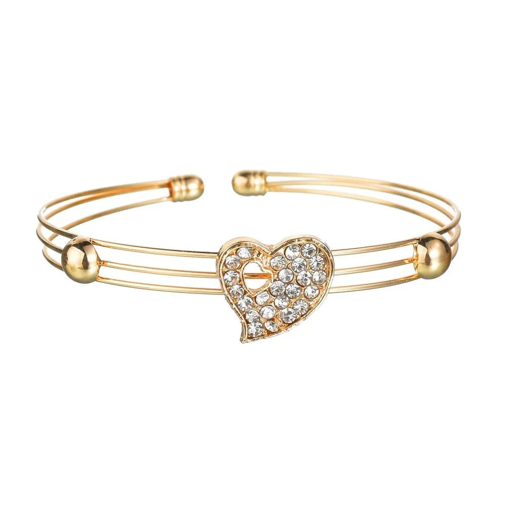 Gold-colour alloy jewellery set with earrings, pendant, and bracelet featuring love and bell patterns