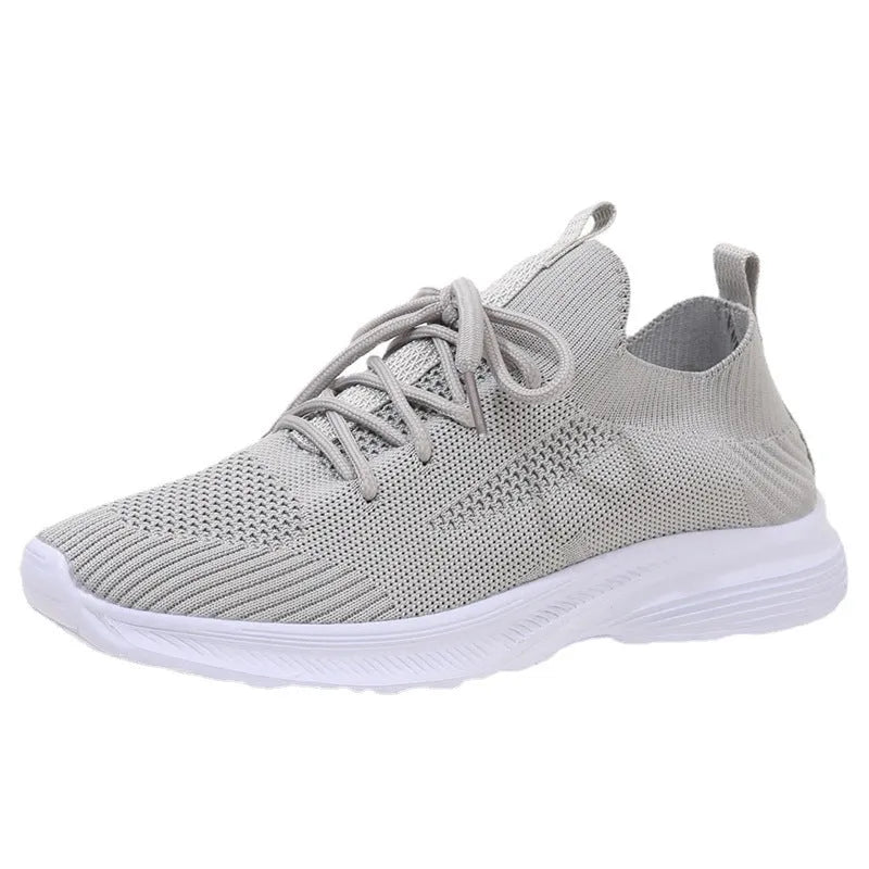 Women's Flyknit mesh running shoes in creamy white colour showing low-top slip-on design and rubber sole.
