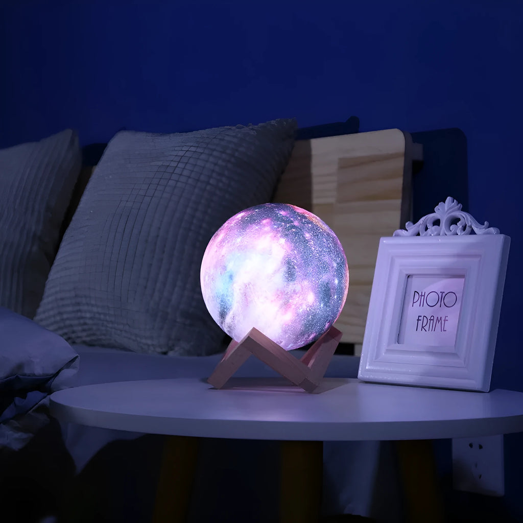 3D printed spherical moon night light with colour changing LED glow on a dark surface.