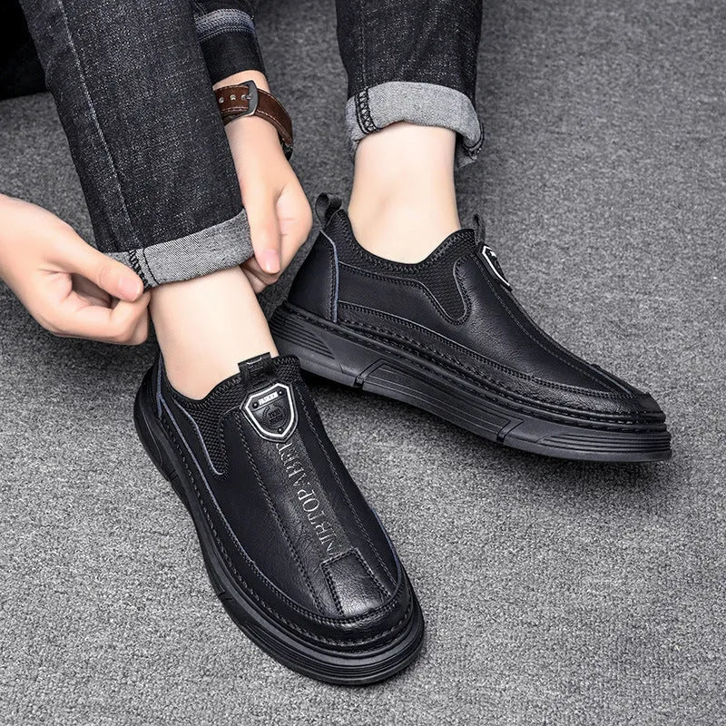 Men's black leather casual shoes with round toe on a plain background.
