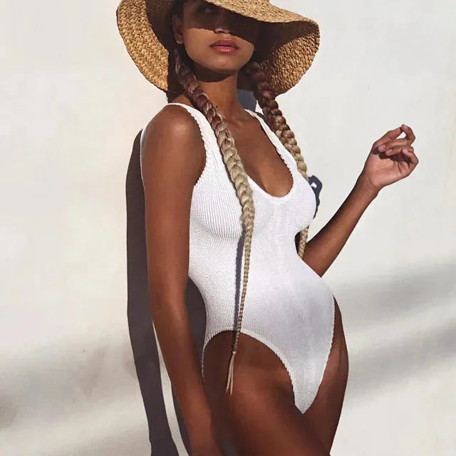 A solid-colour backless one-piece swimsuit for women made from wrinkled seersucker bubble cloth fabric.