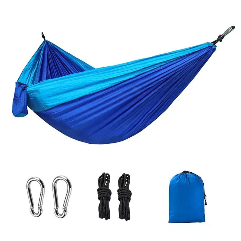 Blue and grey parachute nylon outdoor hammock hung between trees, showing its spacious 270cm length.