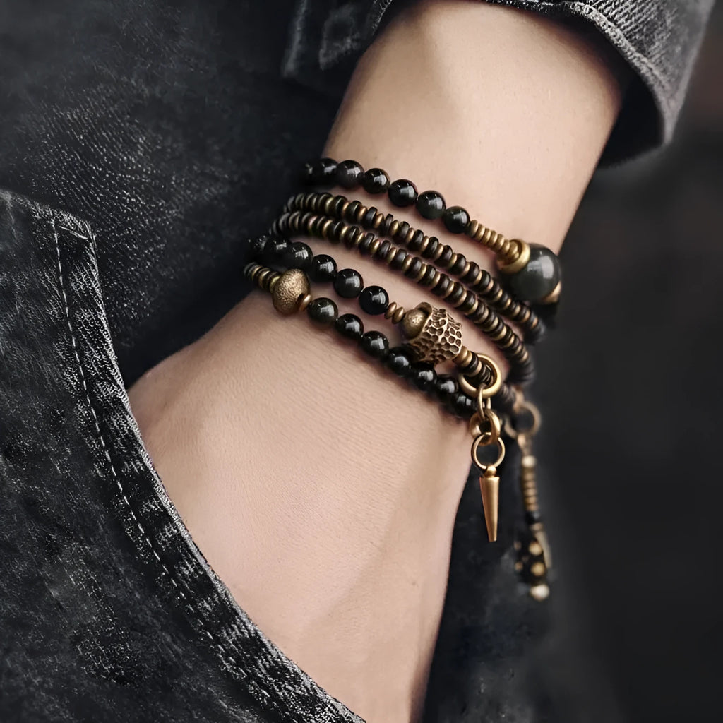 Close-up of a black multi-layered geometric bracelet made from beads, showing its textured construction.