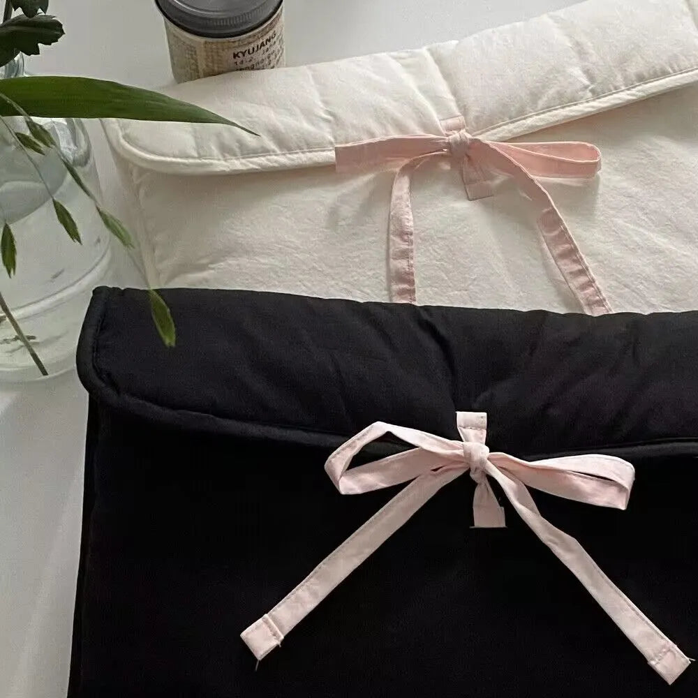 Women's black quilted laptop bag with ballet bow detailing and striped pattern showing laptop compartment
