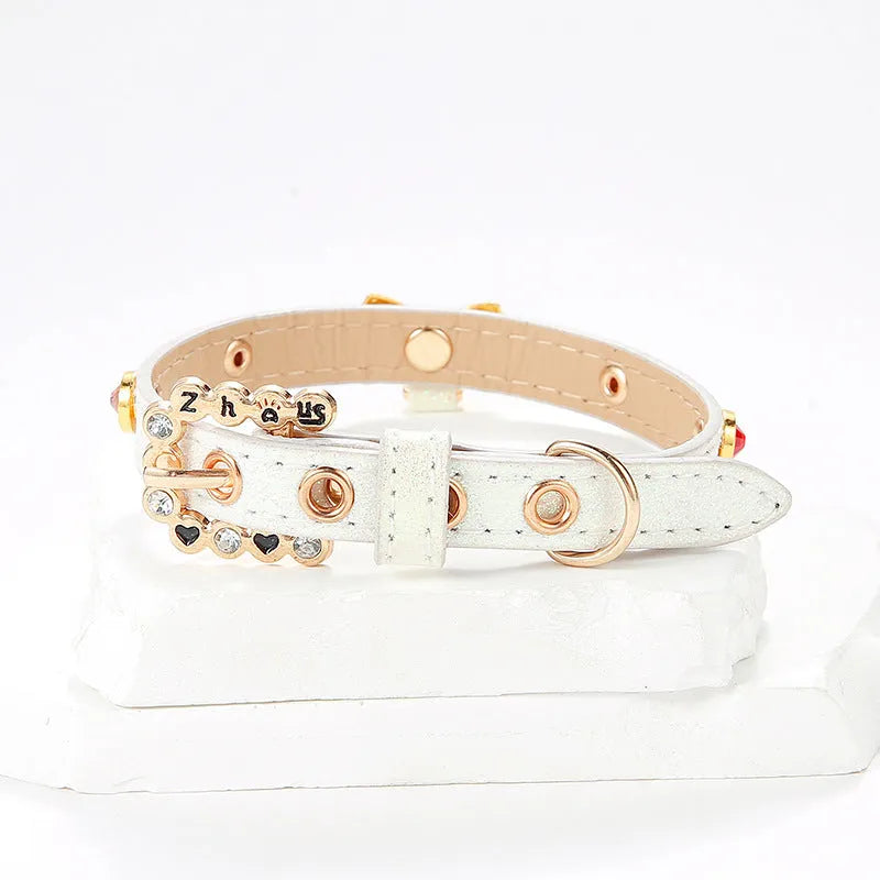 White PU leather cat collar with diamond alloy bow displayed on a surface, showing buckle and adjustable length