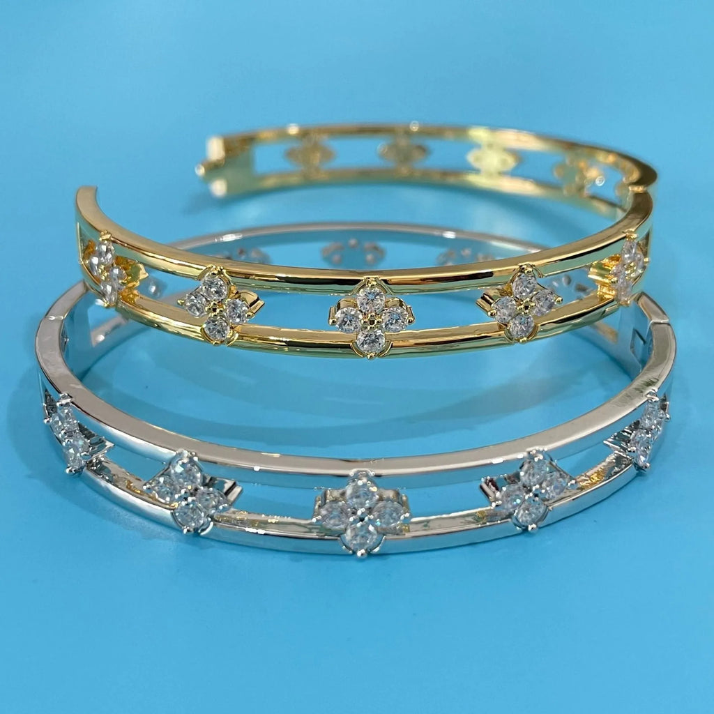 Gold and silver hollow women's bracelets with inlaid zircon stones and four-leaf clover designs.