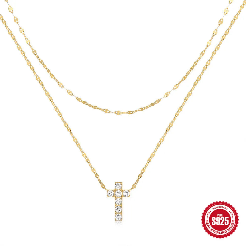 Close-up of a double-layer sterling silver cross pendant on a clavicle chain, available in gold and white gold finishes.