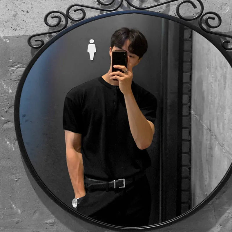 Man wearing a thin black loose-fit knitted short-sleeved pullover shirt.