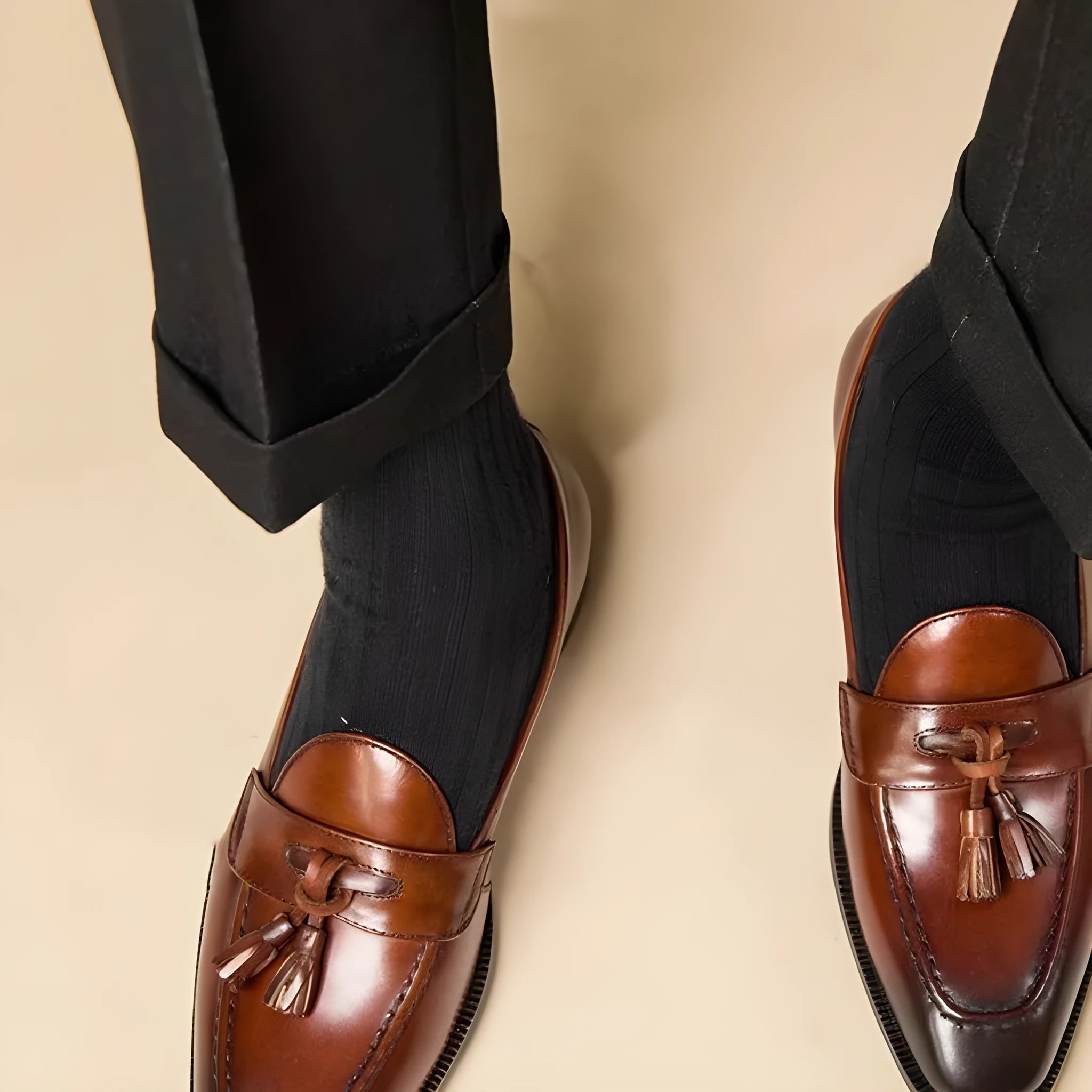 Men's leather tassel loafers in black and brown with polished finish and rubber soles