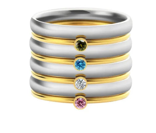 Close-up of a geometric titanium steel ring with an engraved superimposed pattern, shown in a December birthstone colour.