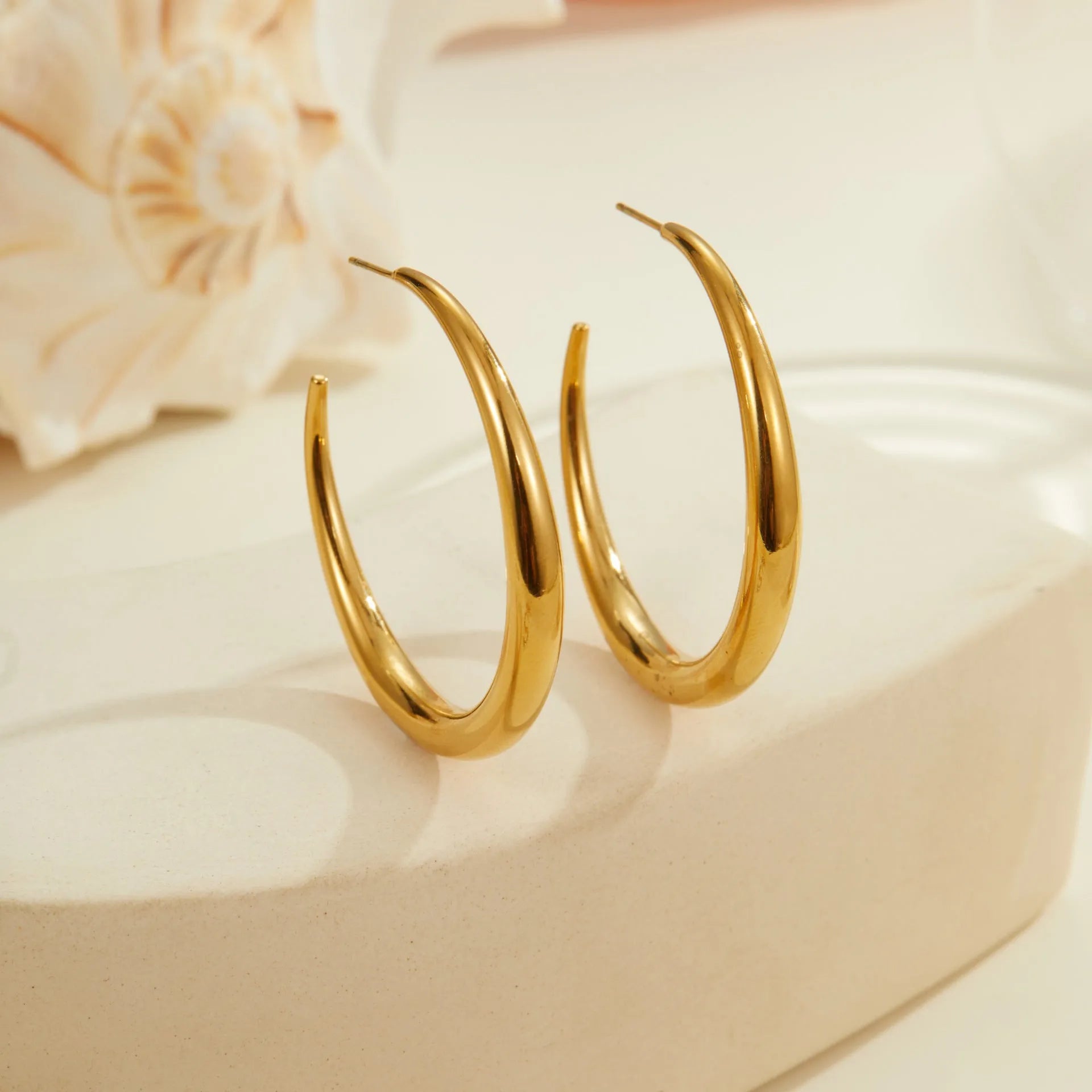 Titanium steel hoop earrings in gold and steel finishes, available in large and small sizes with simple geometric design