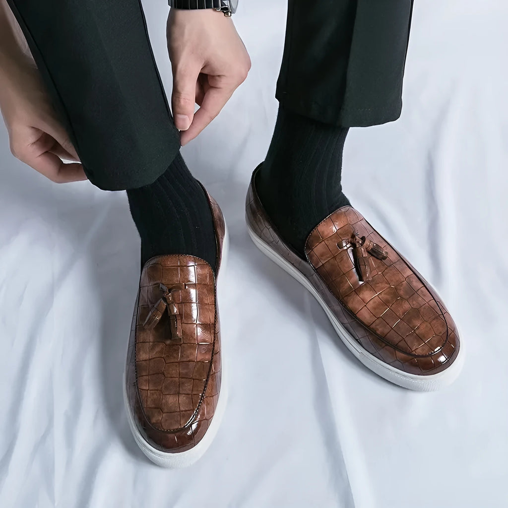 Men's black slip-on sneakers with tassel detail on the vamp and a round toe.