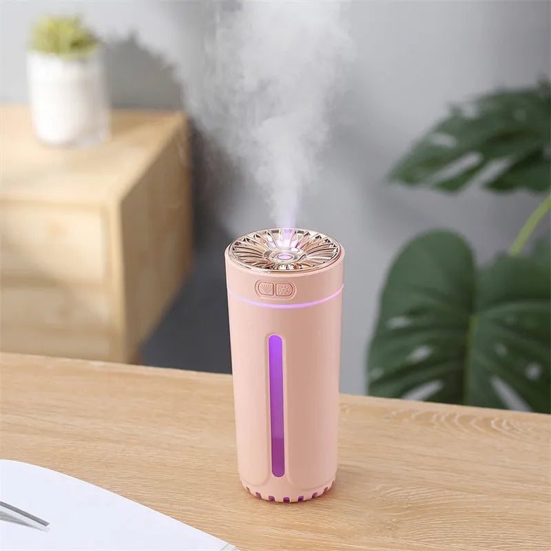 Black portable wireless ultrasonic humidifier with colourful LED lights on a car cup holder.