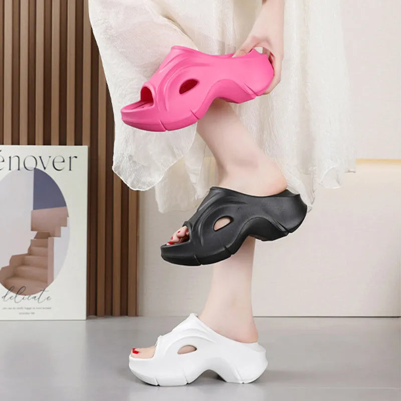 Women's white thick-soled EVA beach slippers with round toe, shown on a sandy background.