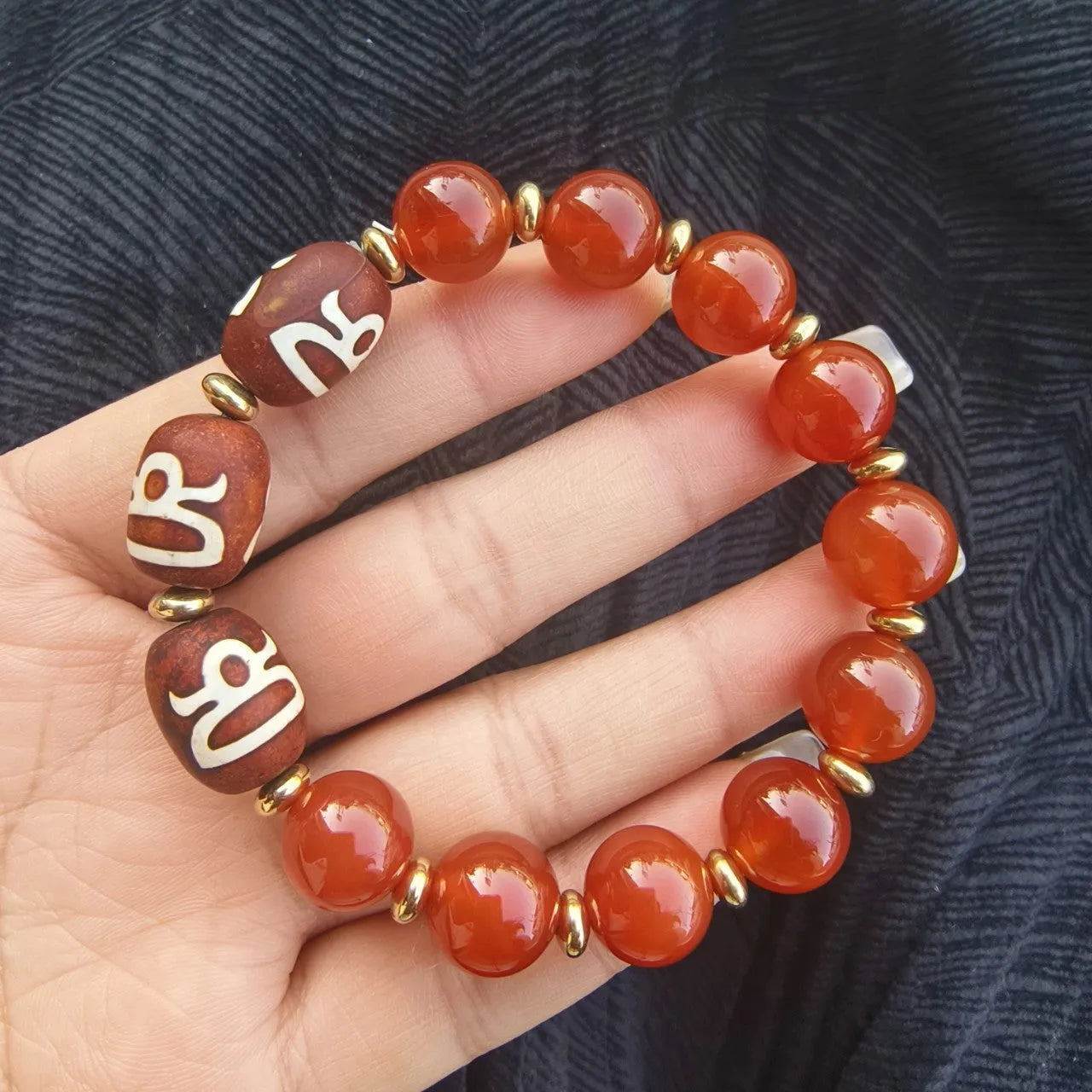 Distressed agate Tibet bead bracelet with three-eye motifs and multiple traditional bead styles on wrist