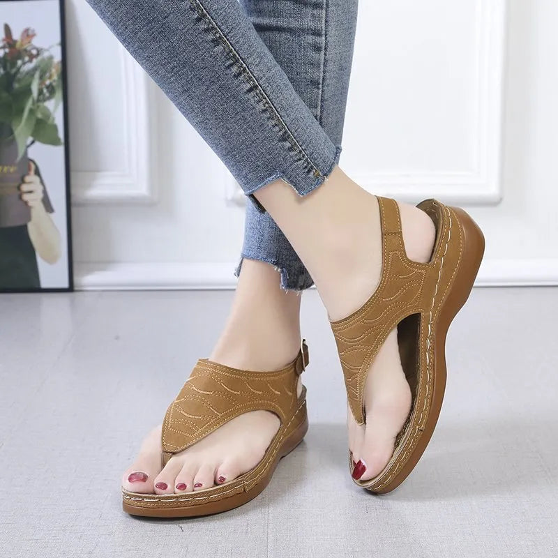 Women's wedge heel flip flop sandals with an adjustable back buckle strap in black.