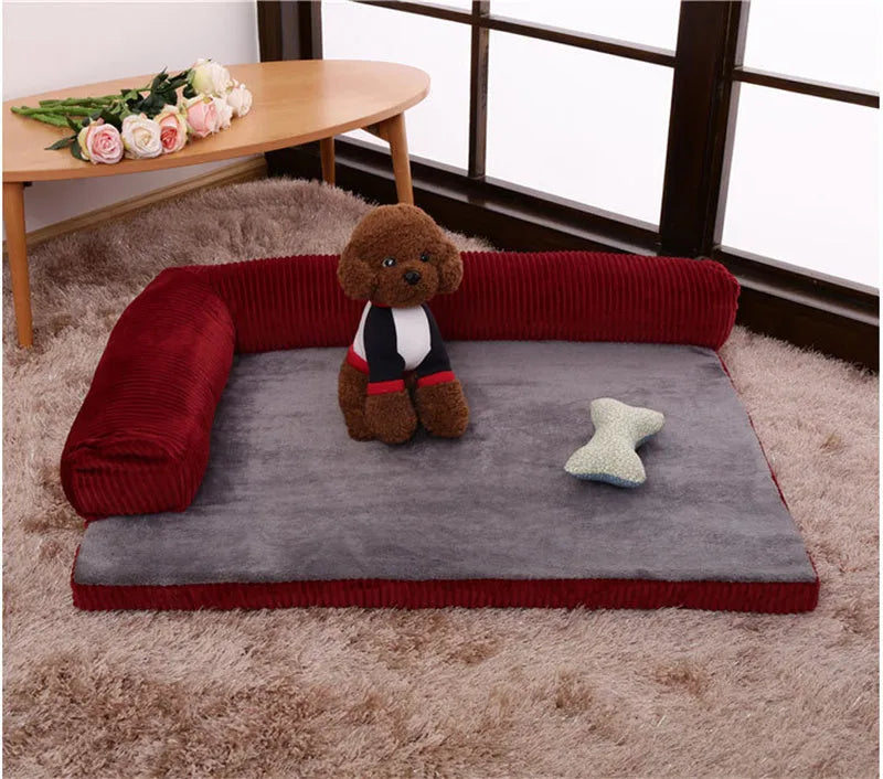 Grey corduroy dog sofa bed with raised sides and a non-slip base on a wooden floor.