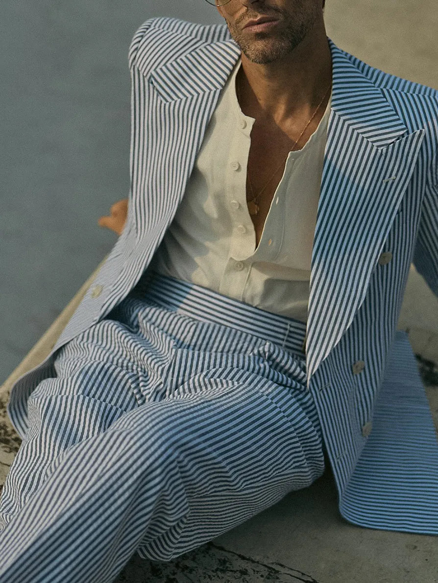Blue and white striped polyester suit set with blazer and trousers on hanger