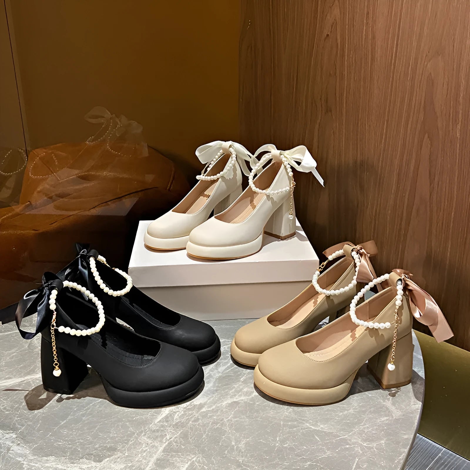 Women's beige Mary Jane shoes with chunky heel and ankle strap buckle on a wooden floor.