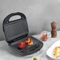 Black double-sided electric sandwich pan with brushed stainless steel lid and non-stick coating.