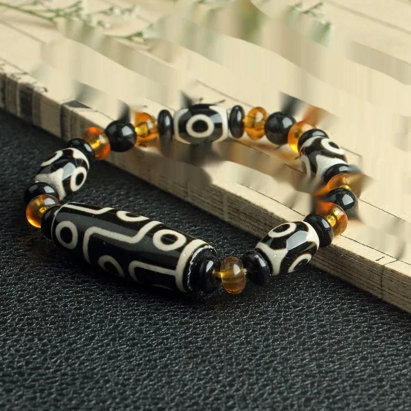 Distressed agate Tibet bead bracelet with three-eye motifs and multiple traditional bead styles on wrist