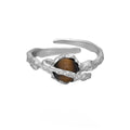Saturn-themed adjustable open ring in electroplated white gold colour with tigereye gemstone detail