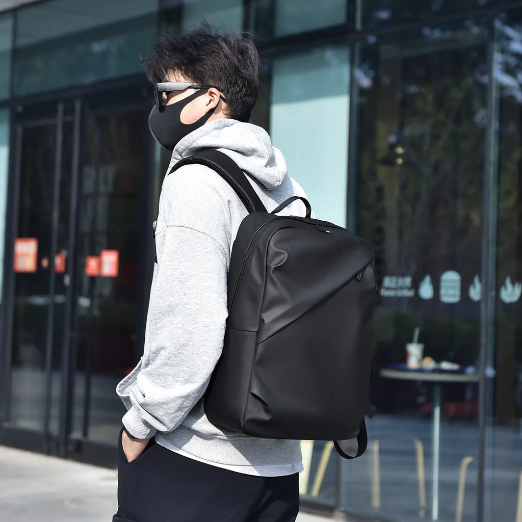 Large black waterproof PU backpack with sewing thread details and separate laptop bag