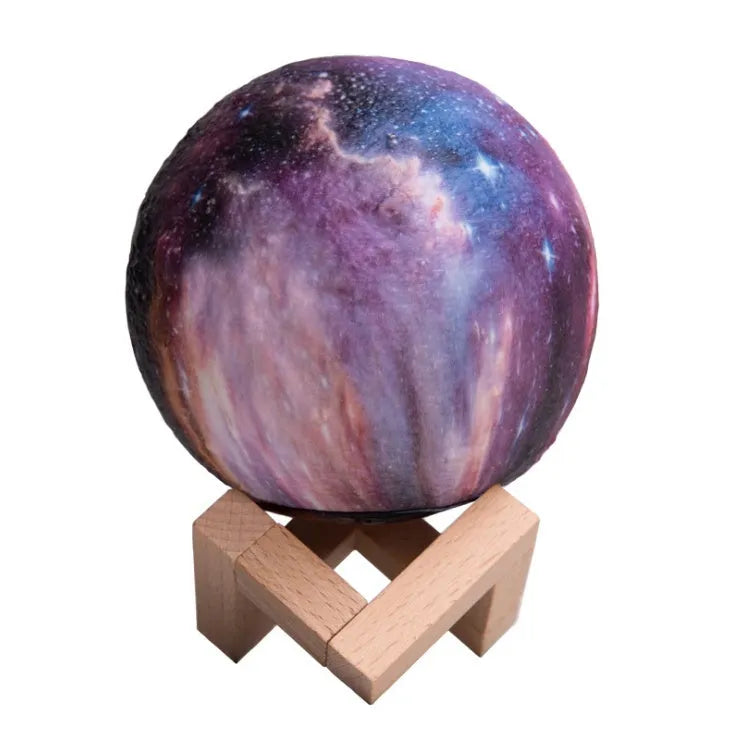 3D printed spherical moon night light with colour changing LED glow on a dark surface.
