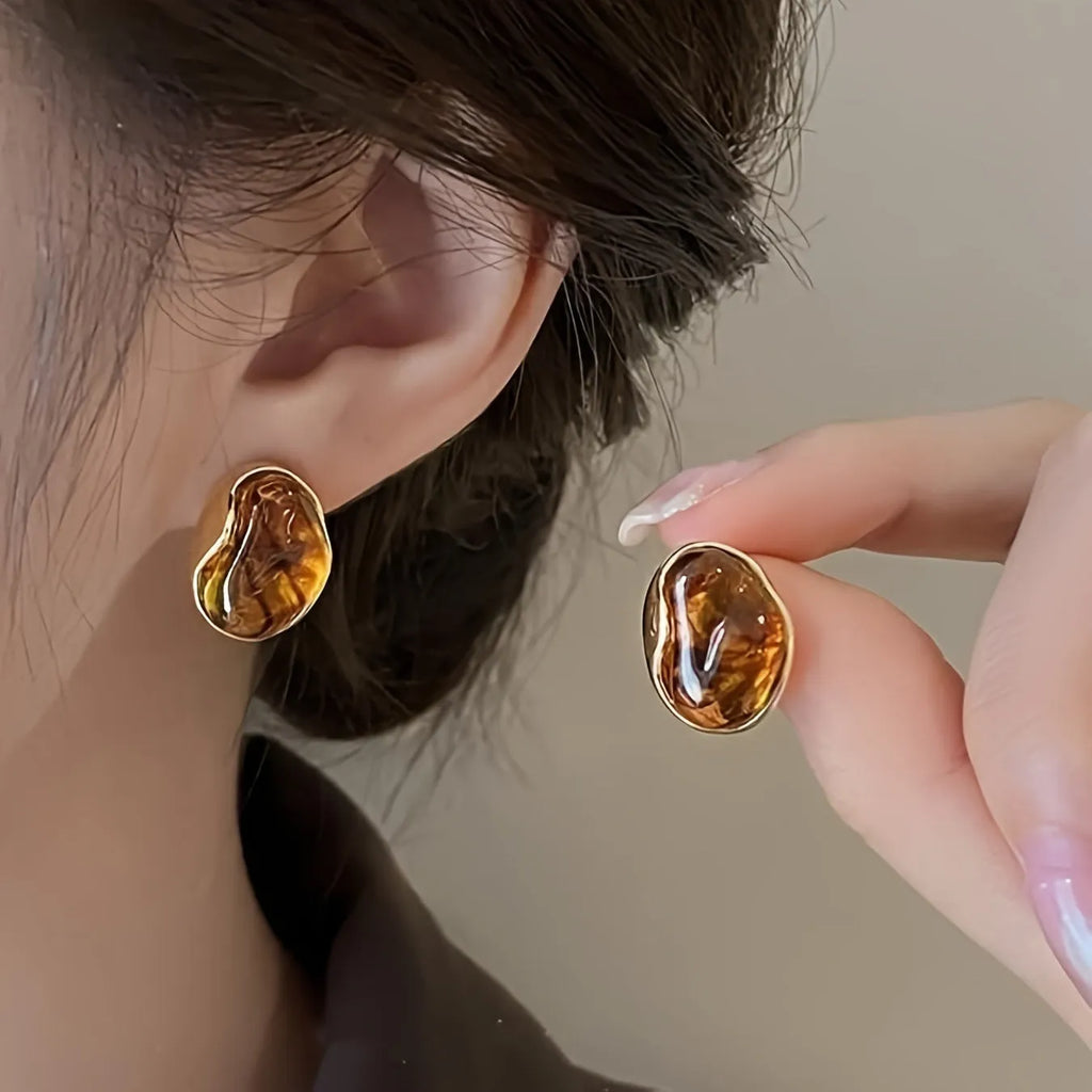 Three pairs of geometric women's earrings with tassel details in irregular, wafer, and water drop styles.