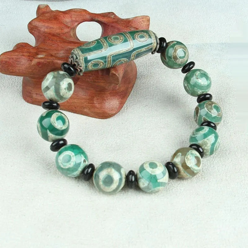 Distressed agate Tibet bead bracelet with three-eye motifs and multiple traditional bead styles on wrist