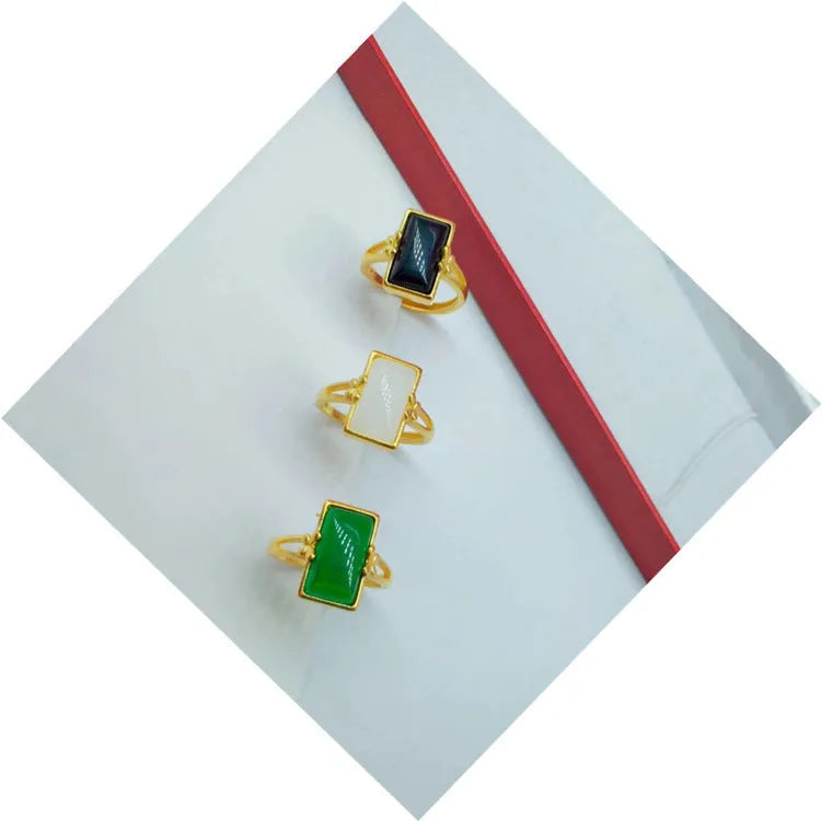 Adjustable gold-plated brass ring with a central gemstone inlay on a model's finger.