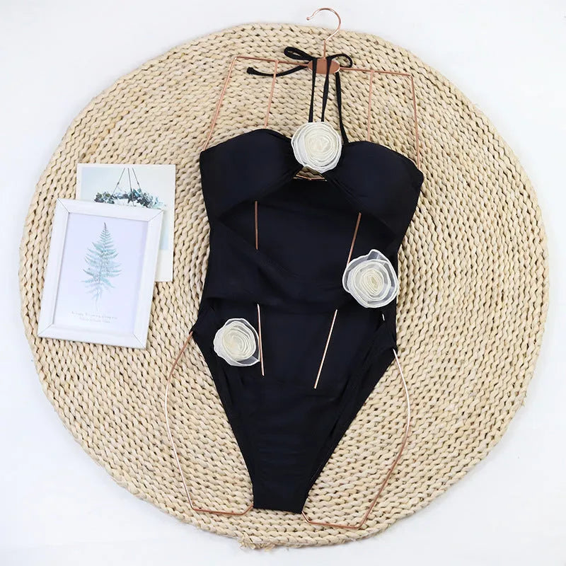 Women's black and blue striped one-piece swimsuit with a 3D flower design.