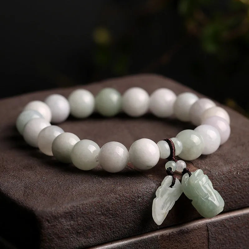 Natural green jade bracelet with Maitreya Buddha charm pendant on a wrist.