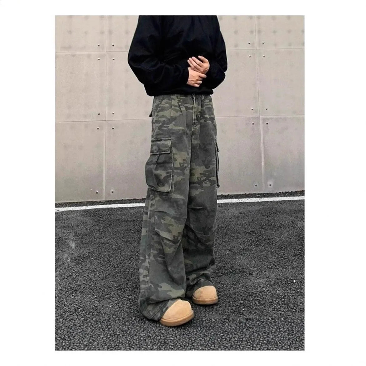 A pair of washed camouflage cotton blend cargo trousers with multiple pockets on a mannequin.